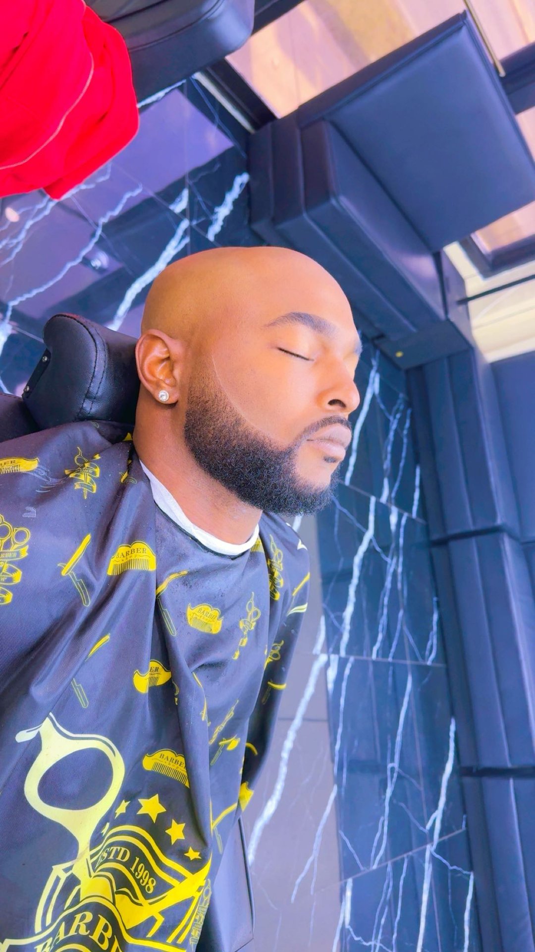 Clean shaved head with a sculpted full beard